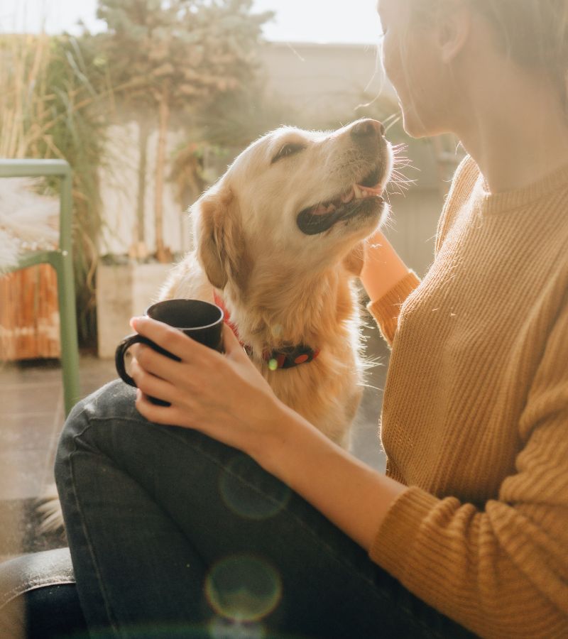 a woman with her dog having coffee